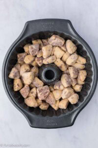 Cinnamon roll pieces added to bundt pan.
