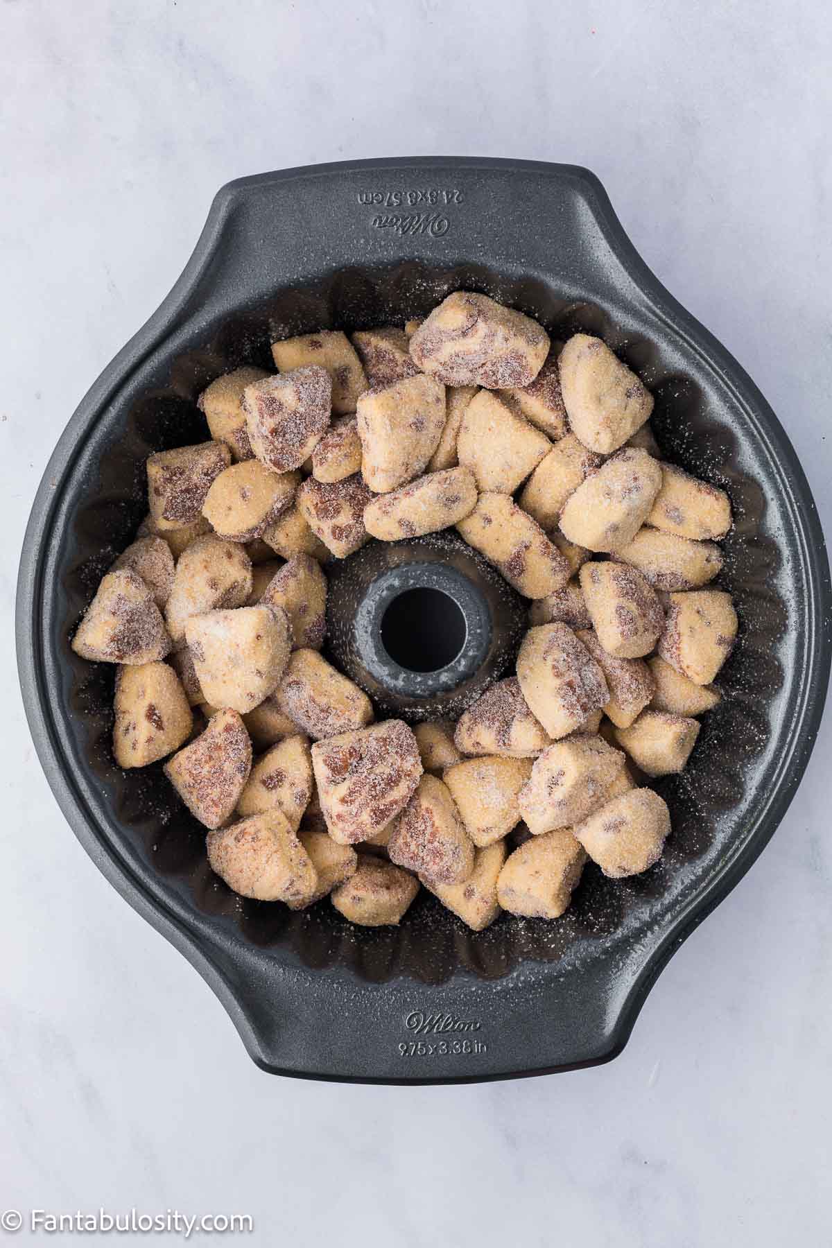 Cinnamon roll pieces added to bundt pan.