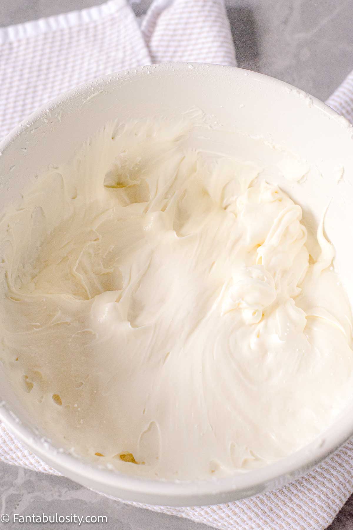 Frosting for hummingbird cake in a mixing bowl.