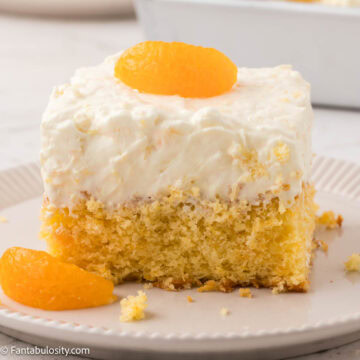 Slice of pea pickin cake on a plate, with mandarin oranges.
