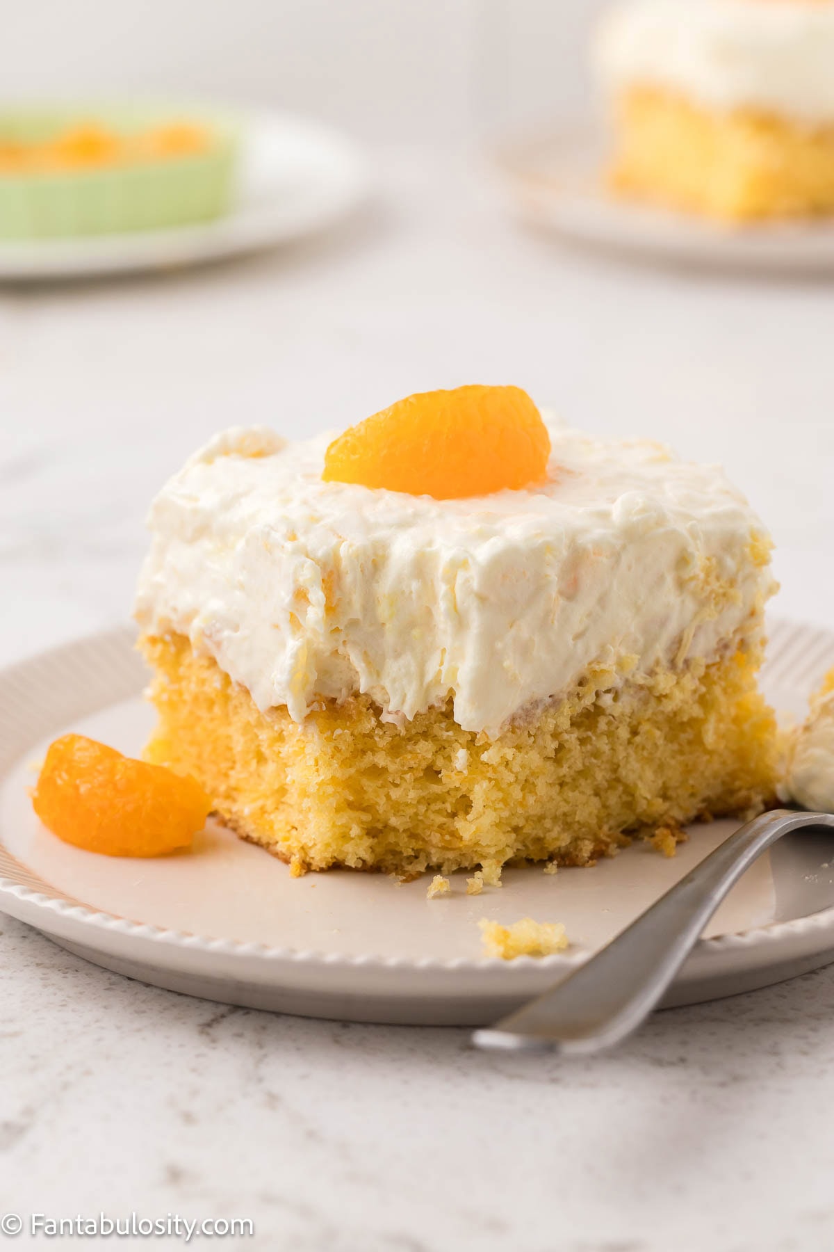 A slice of pea pickin cake on a round plate, sitting next to fork.