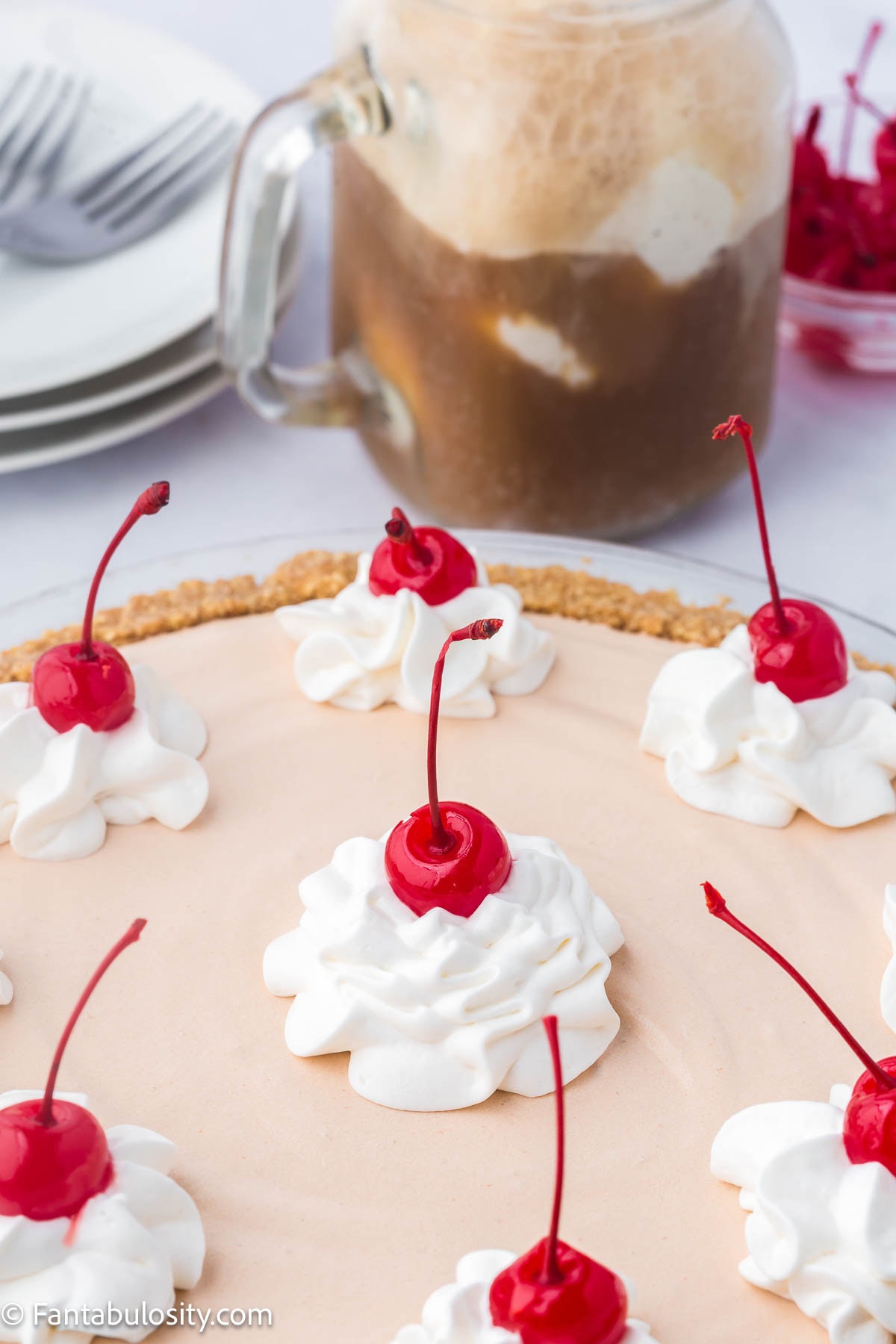 Root Beer Float pie topped with whipped cream and maraschino cherries. 