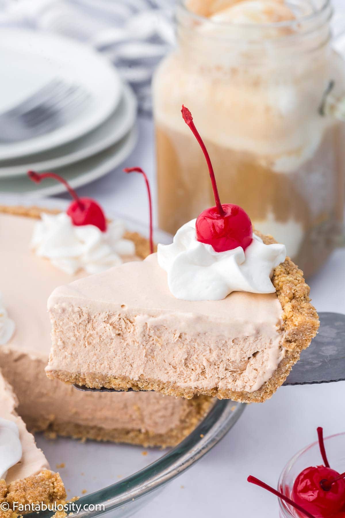 Slice of root beer float pie being held on spatula next to pie.