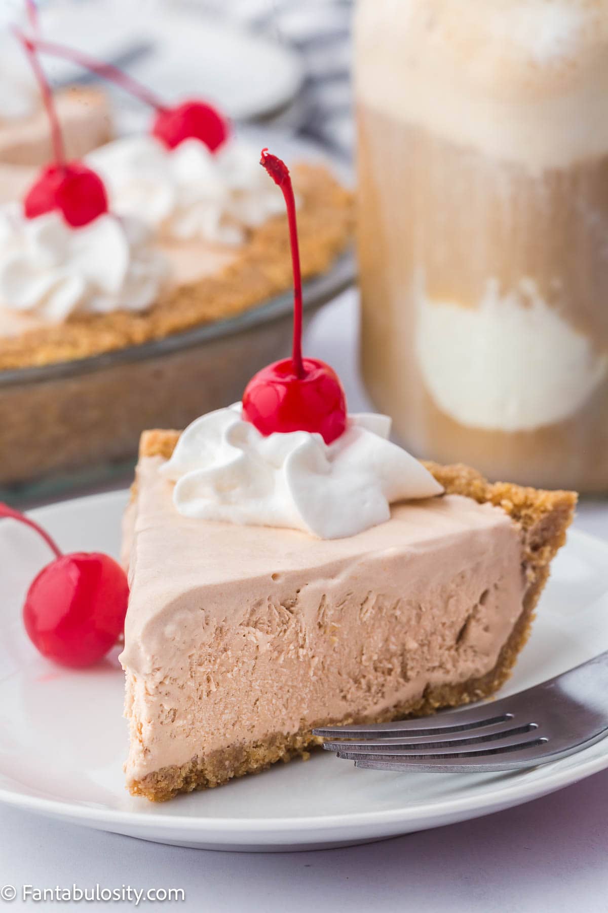 Slice of root beer float pie on plate, with fork resting near it. 