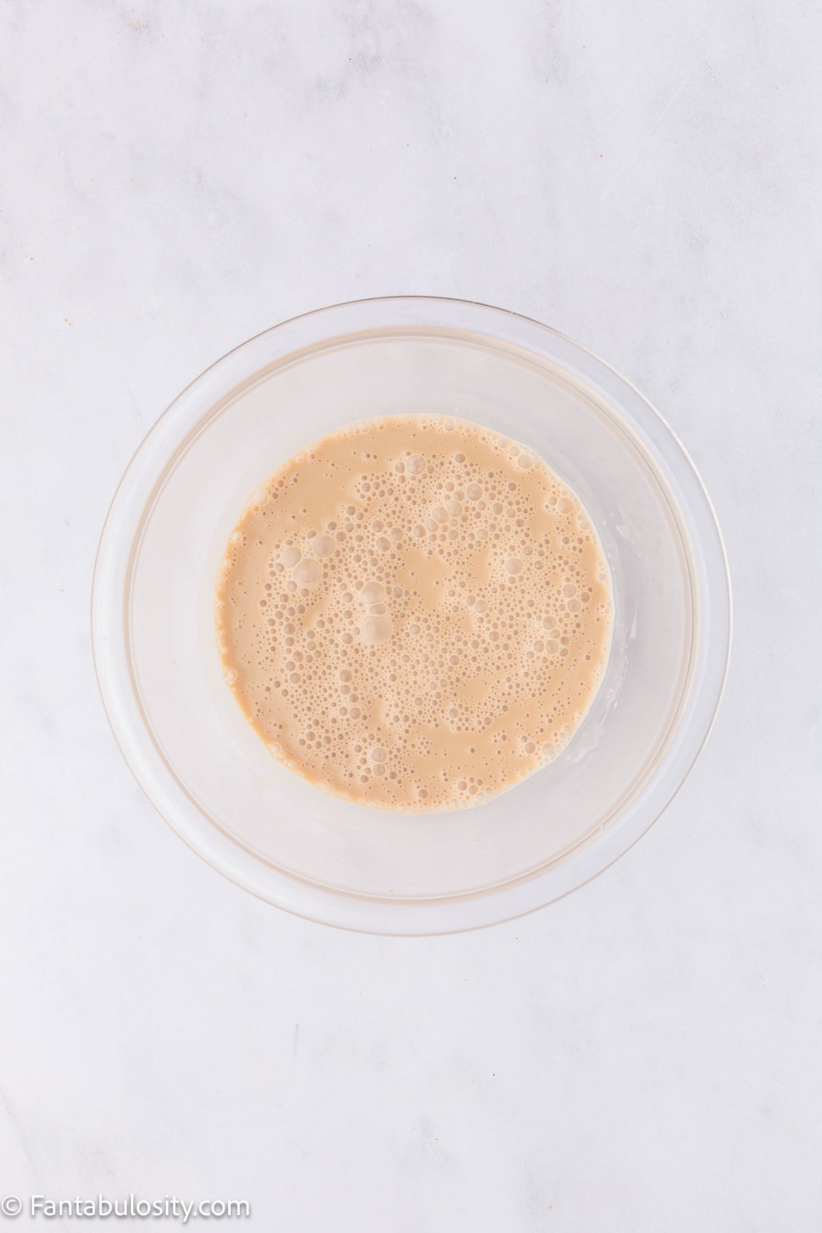 Root beer, root beer extract and milk in mixing bowl.