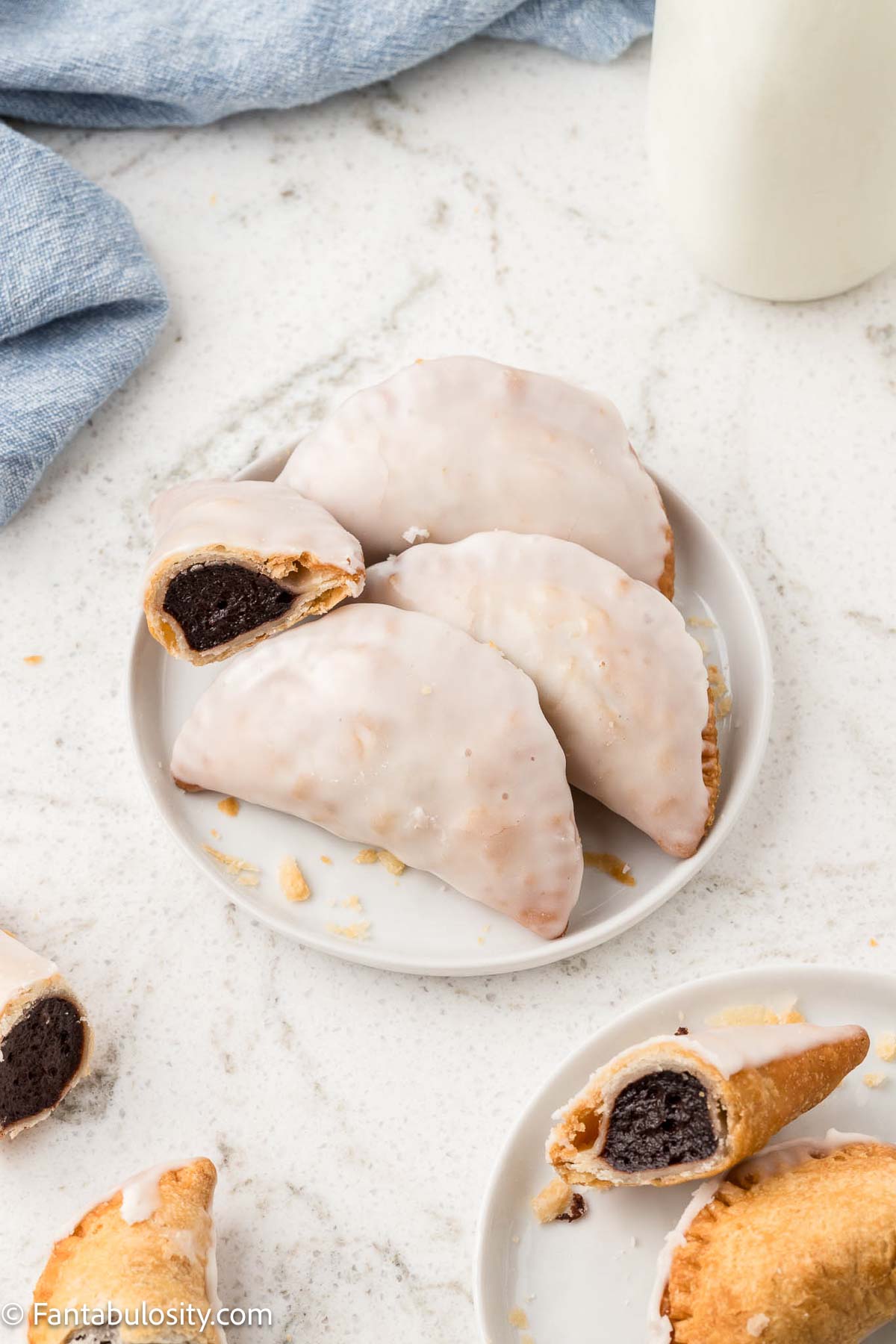 Fried chocolate pies on plate, with one having a bite taken out of it. 