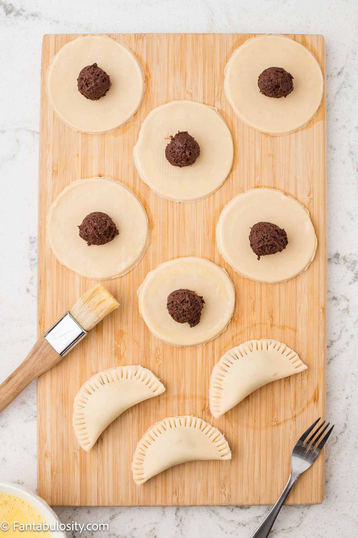 Pie crusts folding over and sealed, to create hand pies.