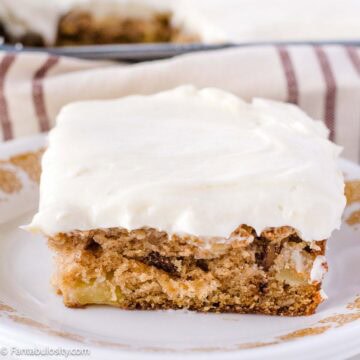 A slice of Harvest cake, with cream cheese frosting, sitting on vintage dessert plate.