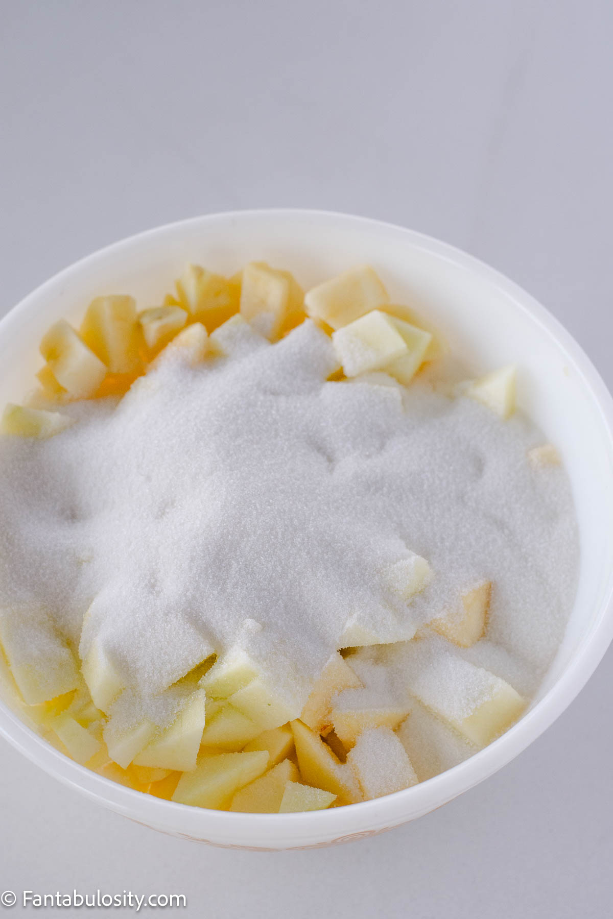 Apples in bowl with sugar.
