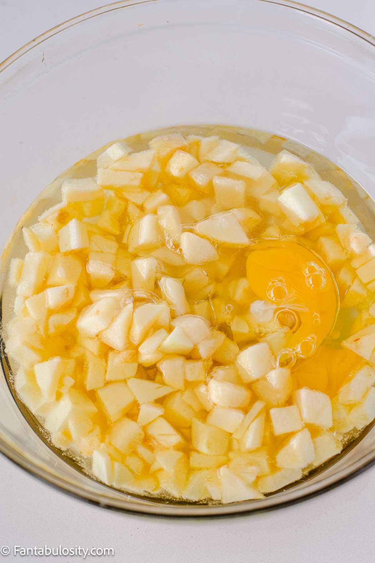Diced apples, eggs, and oil in mixing bowl.