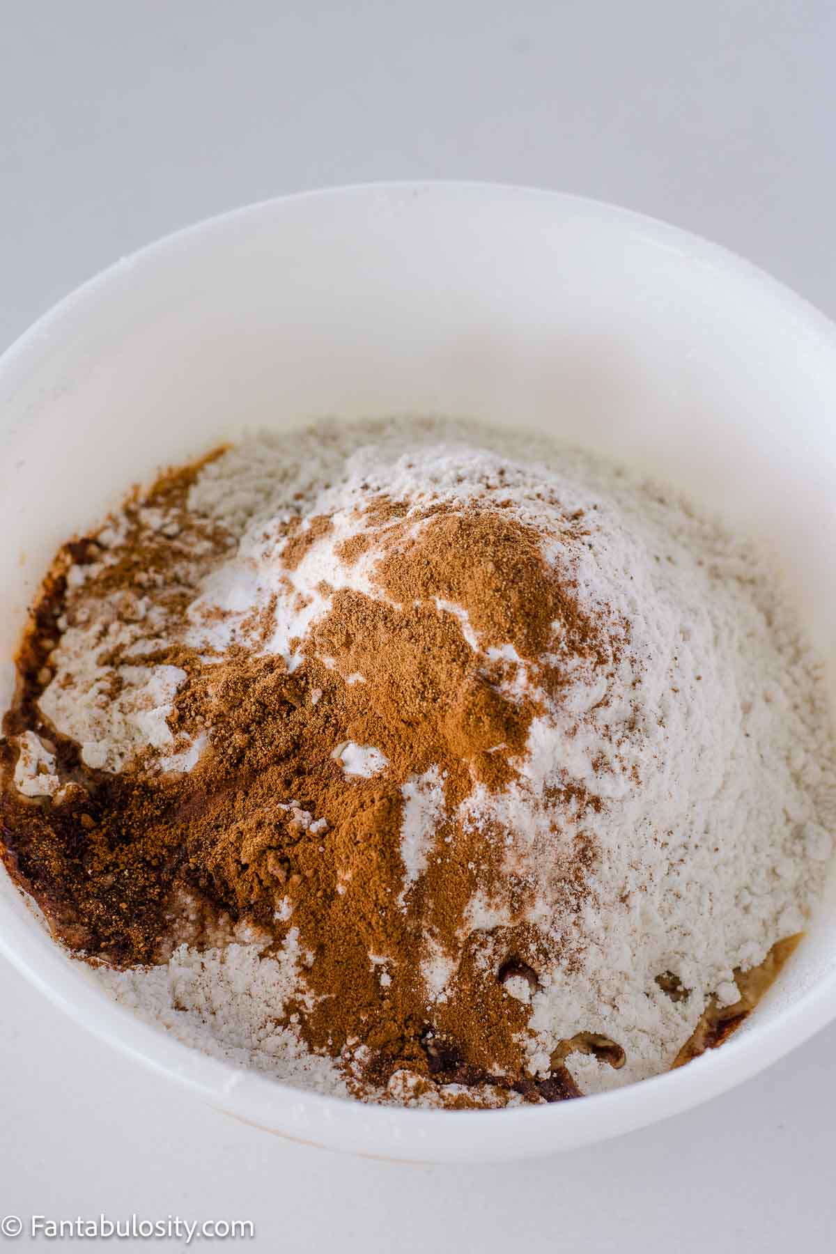 Flour, cinnamon, nutmeg and baking soda in mixing bowl.