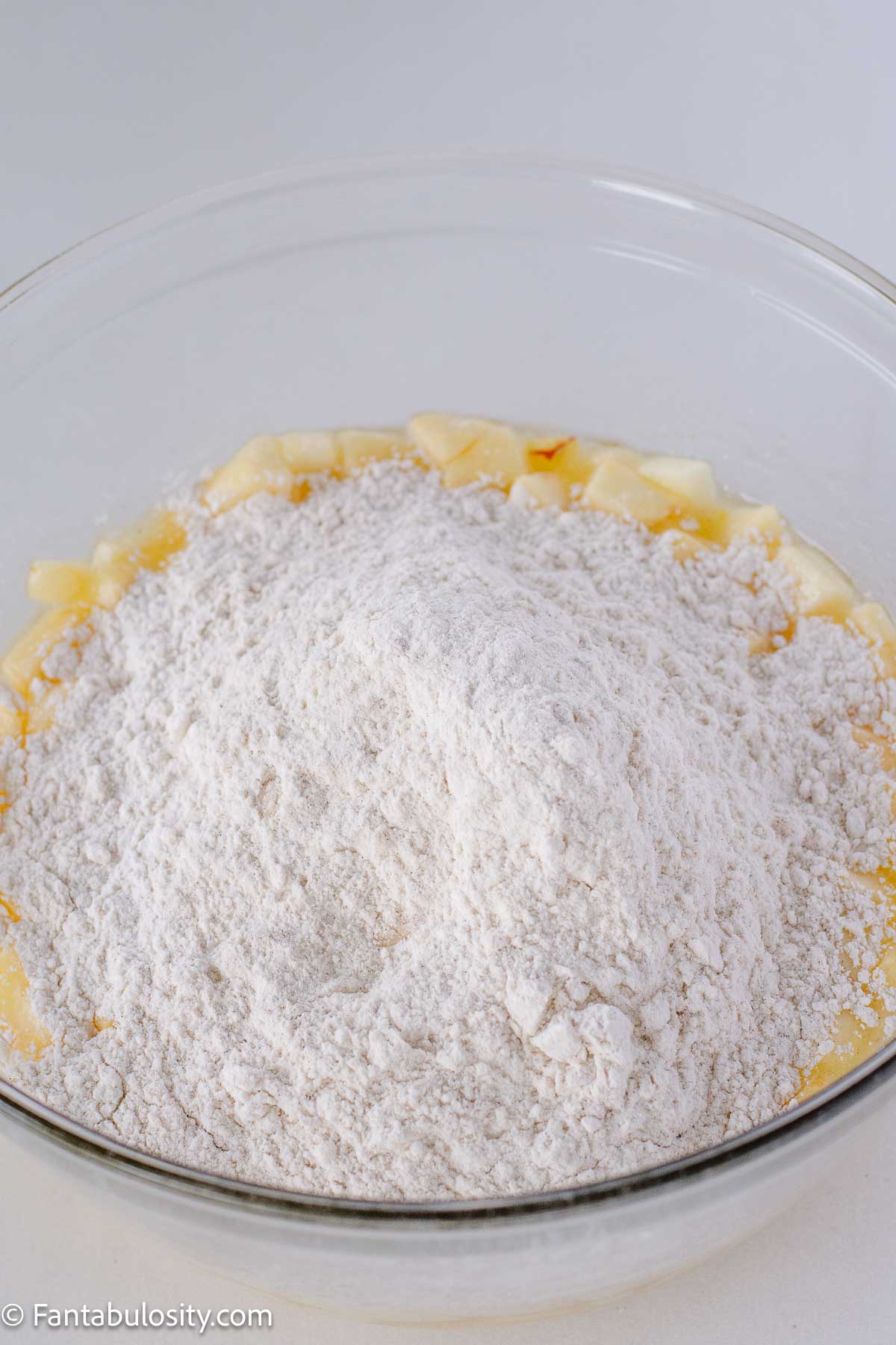 Dry ingredients and vanilla added in to eggs, oil, and apples in mixing bowl.