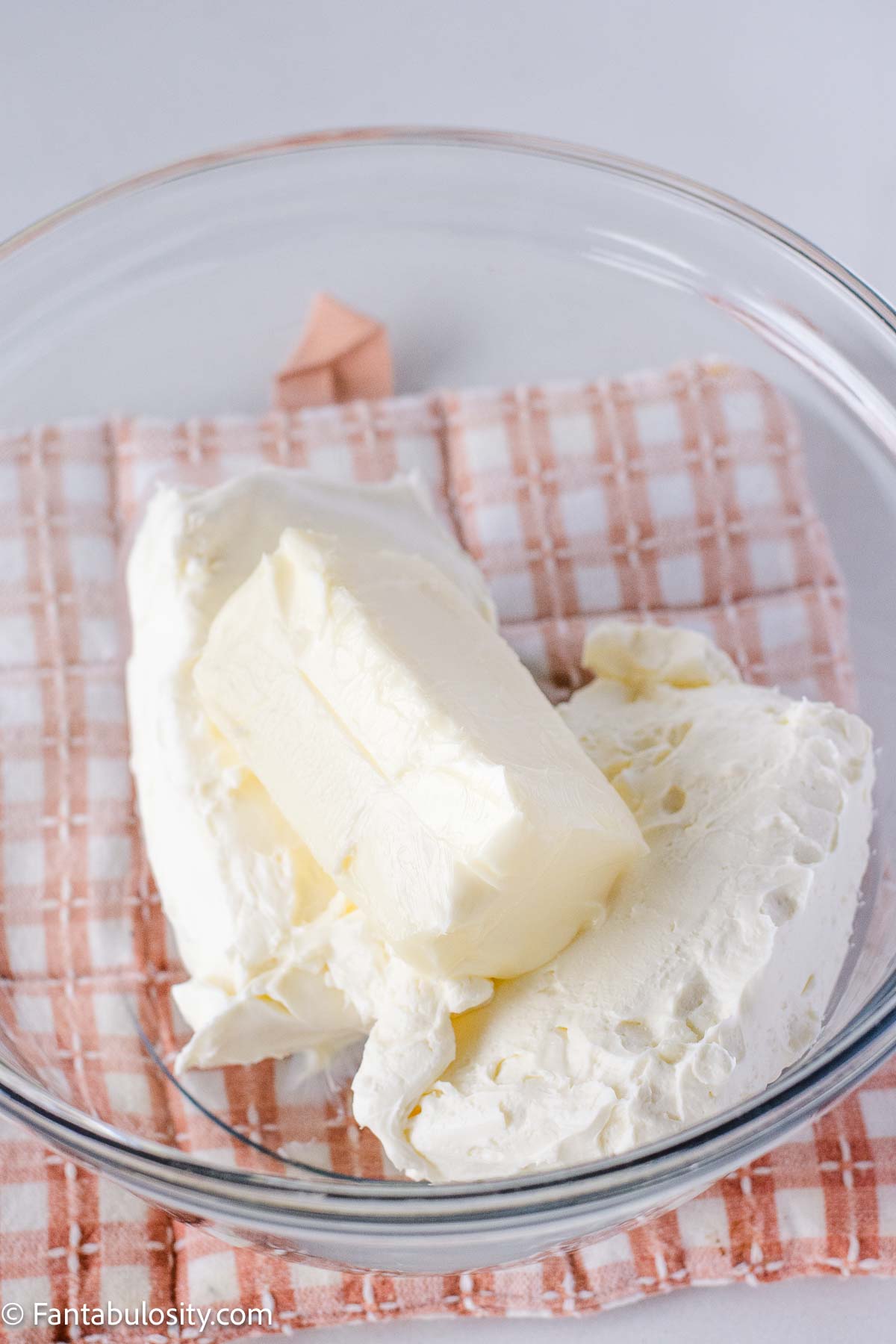 Cream cheese and butter in mixing bowl.