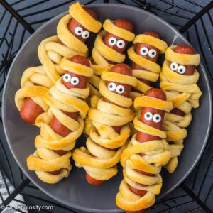Hot Dog Mummies resting on round plate.