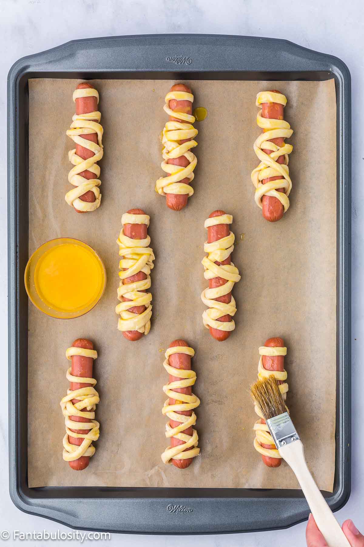 Pastry brush, brushing garlic butter on to crescent rolls, on hot dogs.