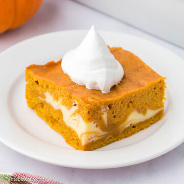 A slice of pumpkin cheesecake cake, on a round plate.