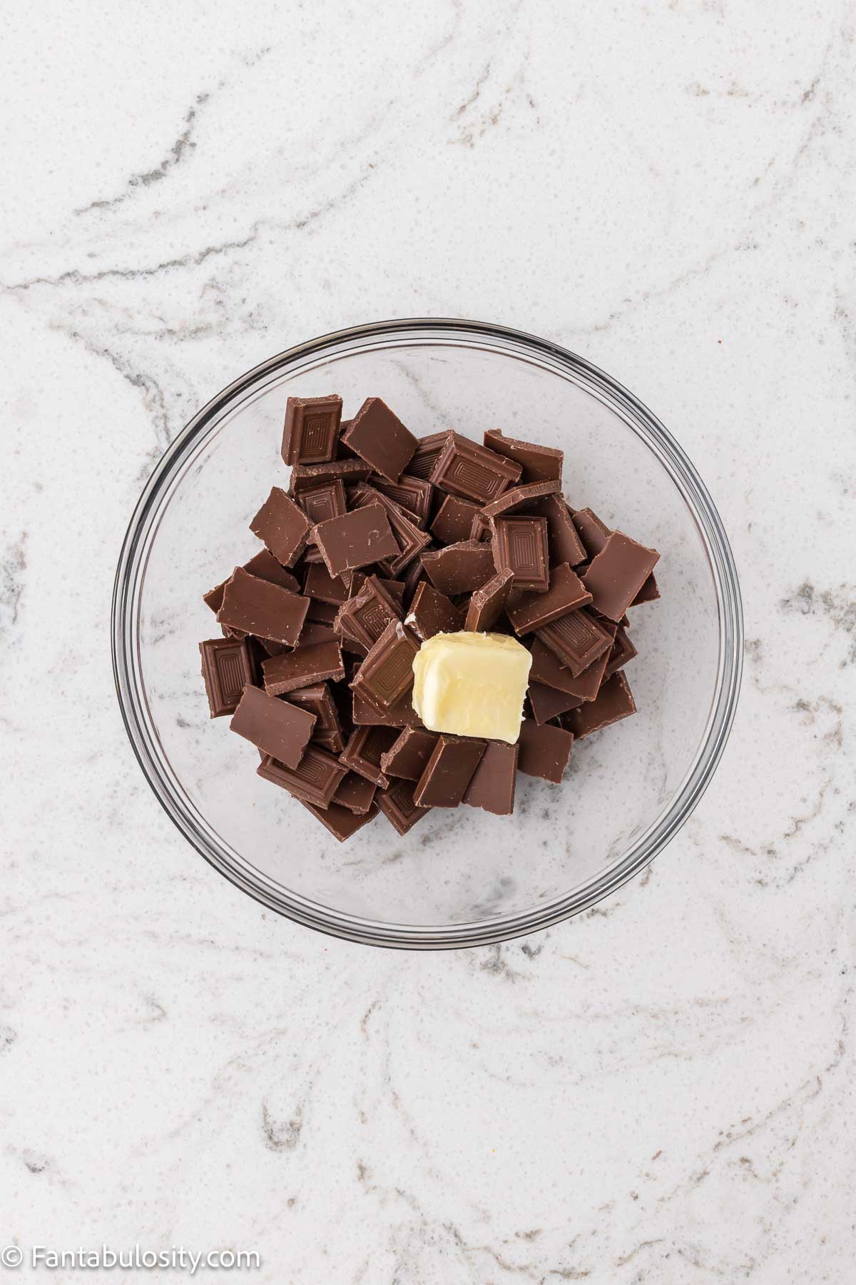 Chocolate bars broken in to pieces, in mixing bowl with butter.