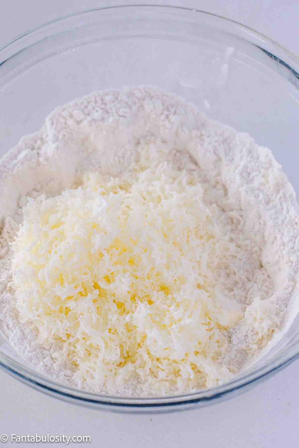 Sifted flour with grated butter in mixing bowl.