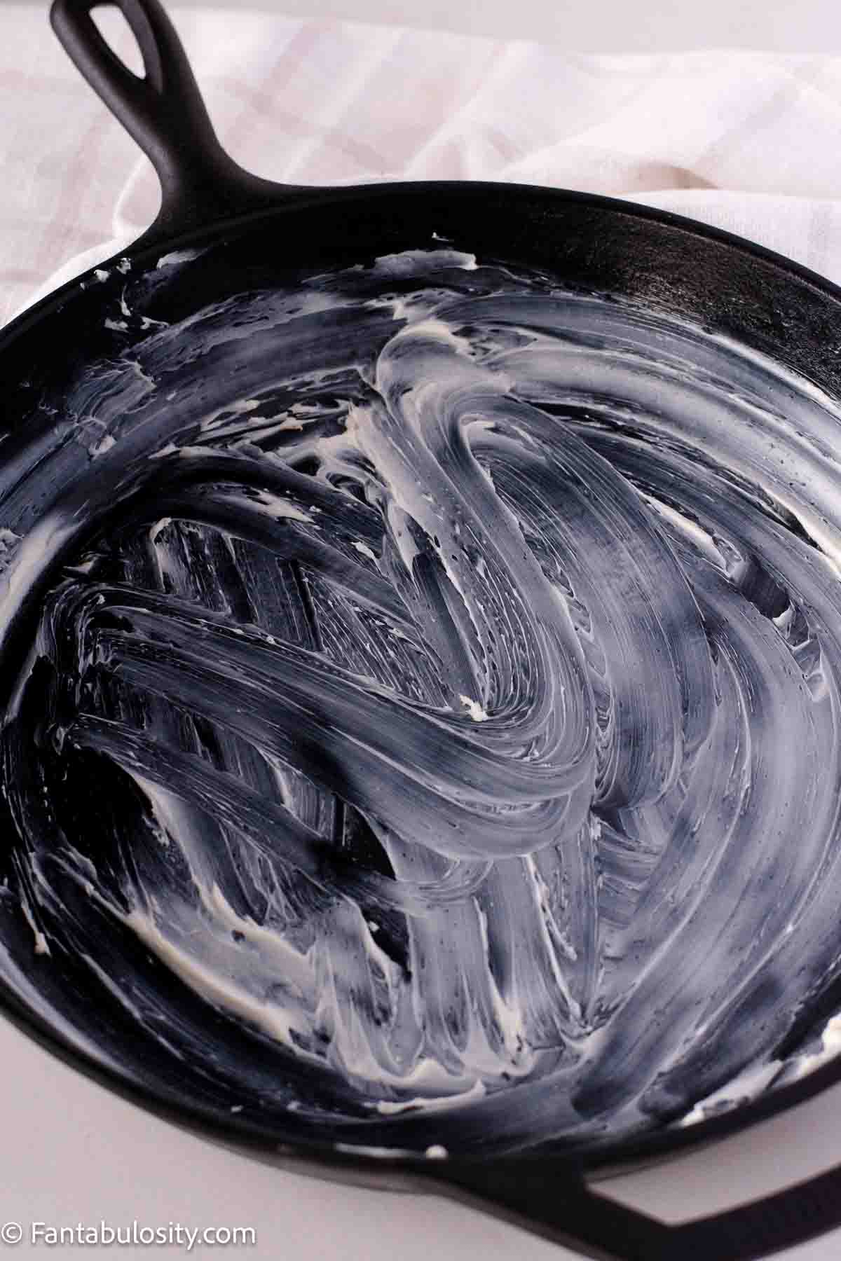 Cast iron skillet covered in salted butter.