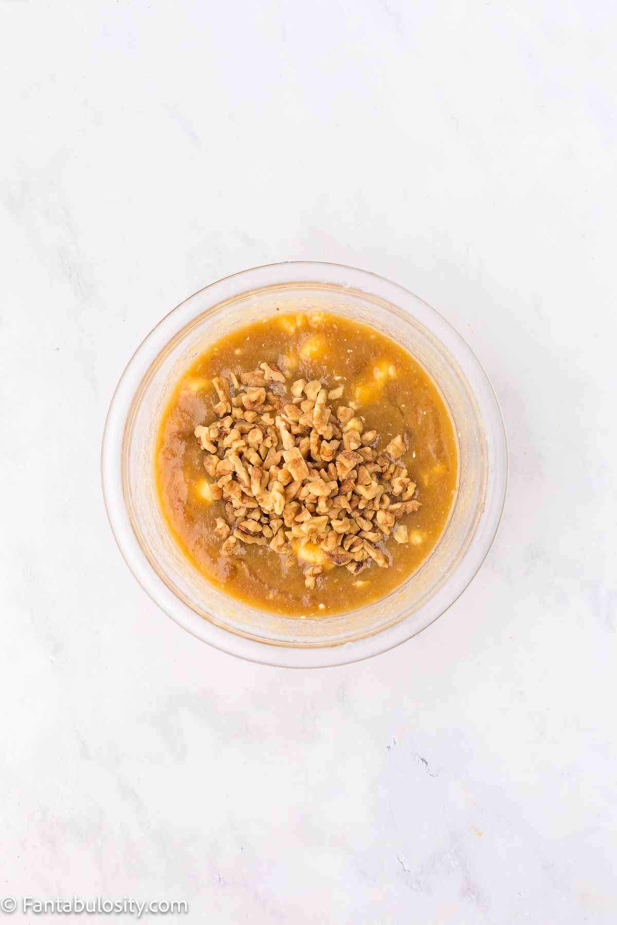 Walnuts added to cake batter in mixing bowl.