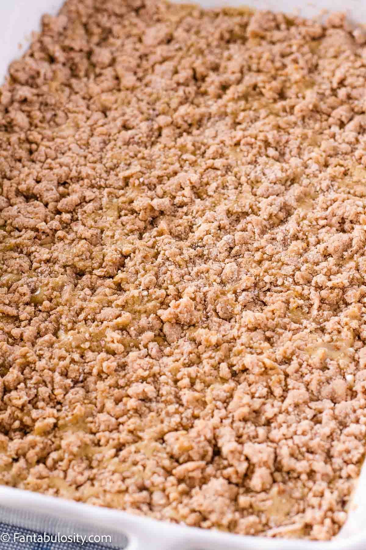 Wet, sandy cake mix and butter mixture on dump cake.