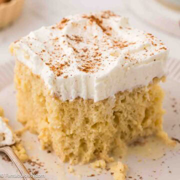 Slice of eggnog tres leches cake on a plate, next to fork.
