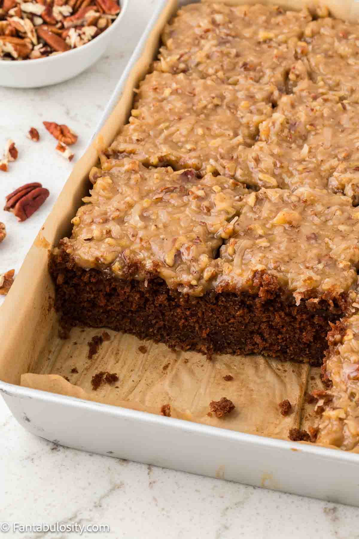German Chocolate Sheet Cake with a couple of pieces missing from the pan.
