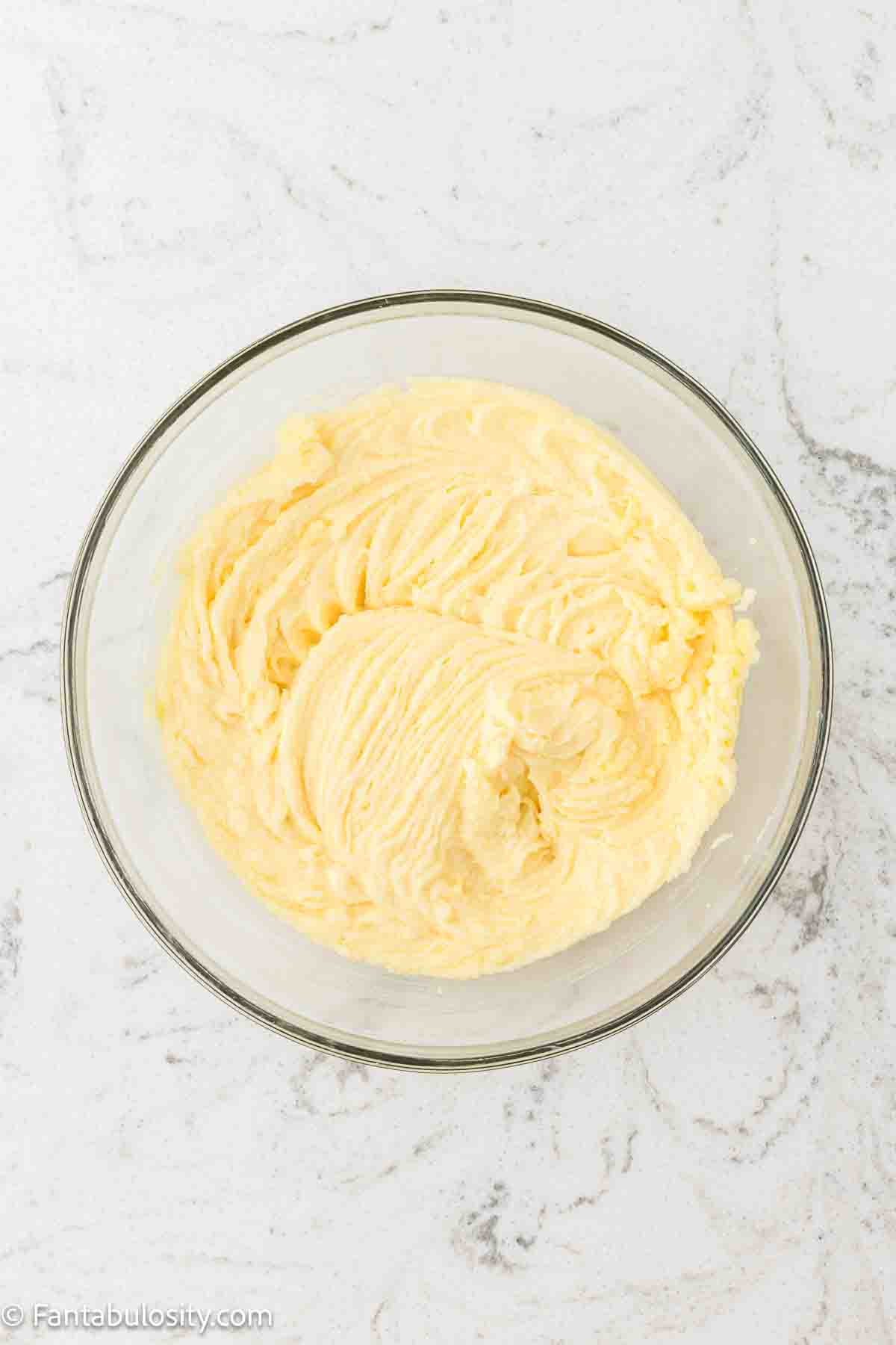 Butter and sugar mixed together in mixing bowl.