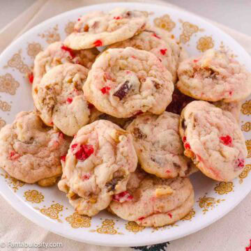Cookies with cherries, dates and walnuts, stacked on vintage plate.