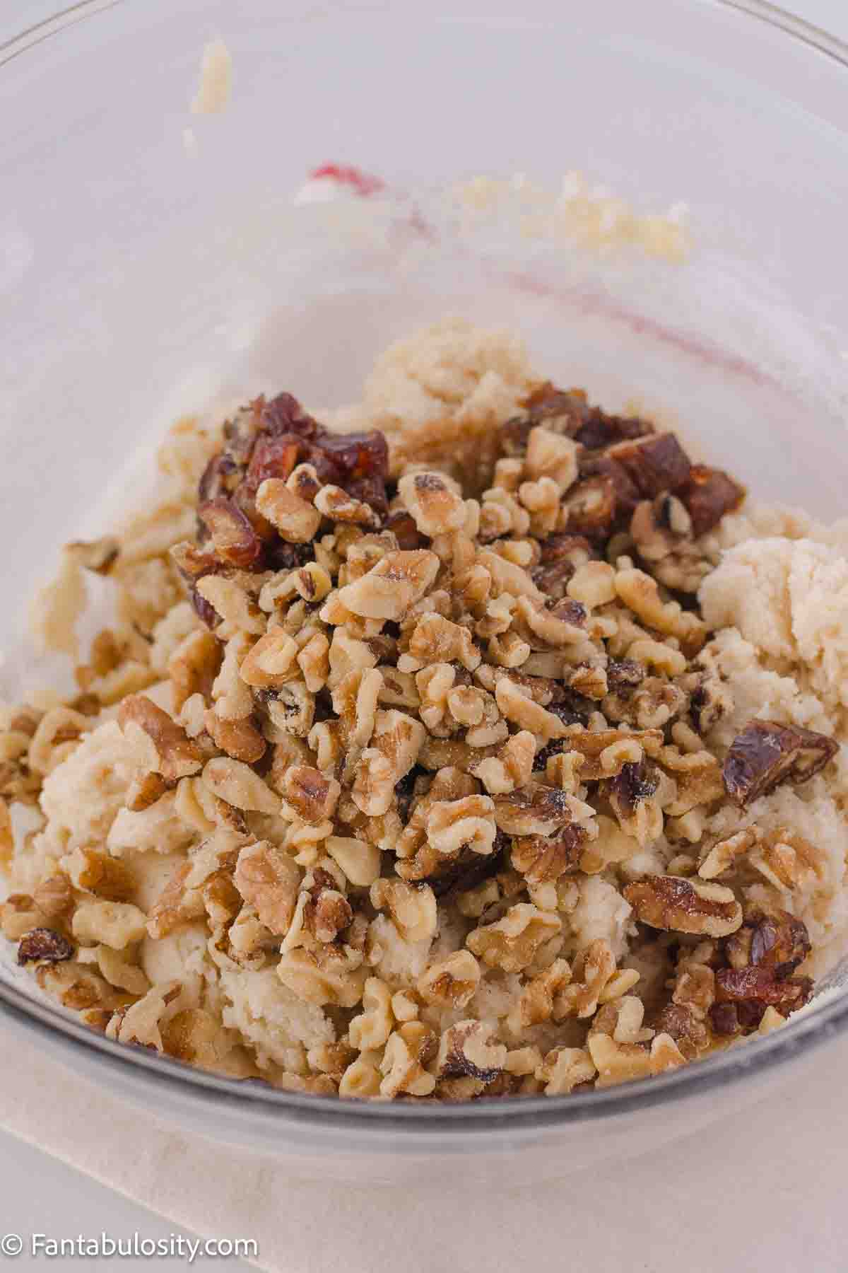 Walnuts and chopped dates in mixing bowl with cookie dough.