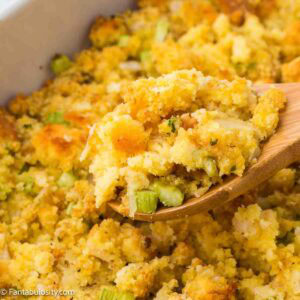 Wooden spoon holding a serving of old-fashioned cornbread dressing.