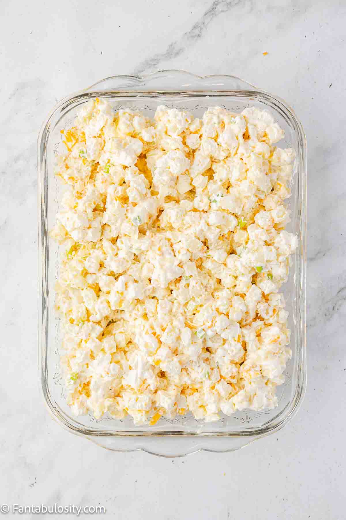 Unbaked party potatoes in baking dish.