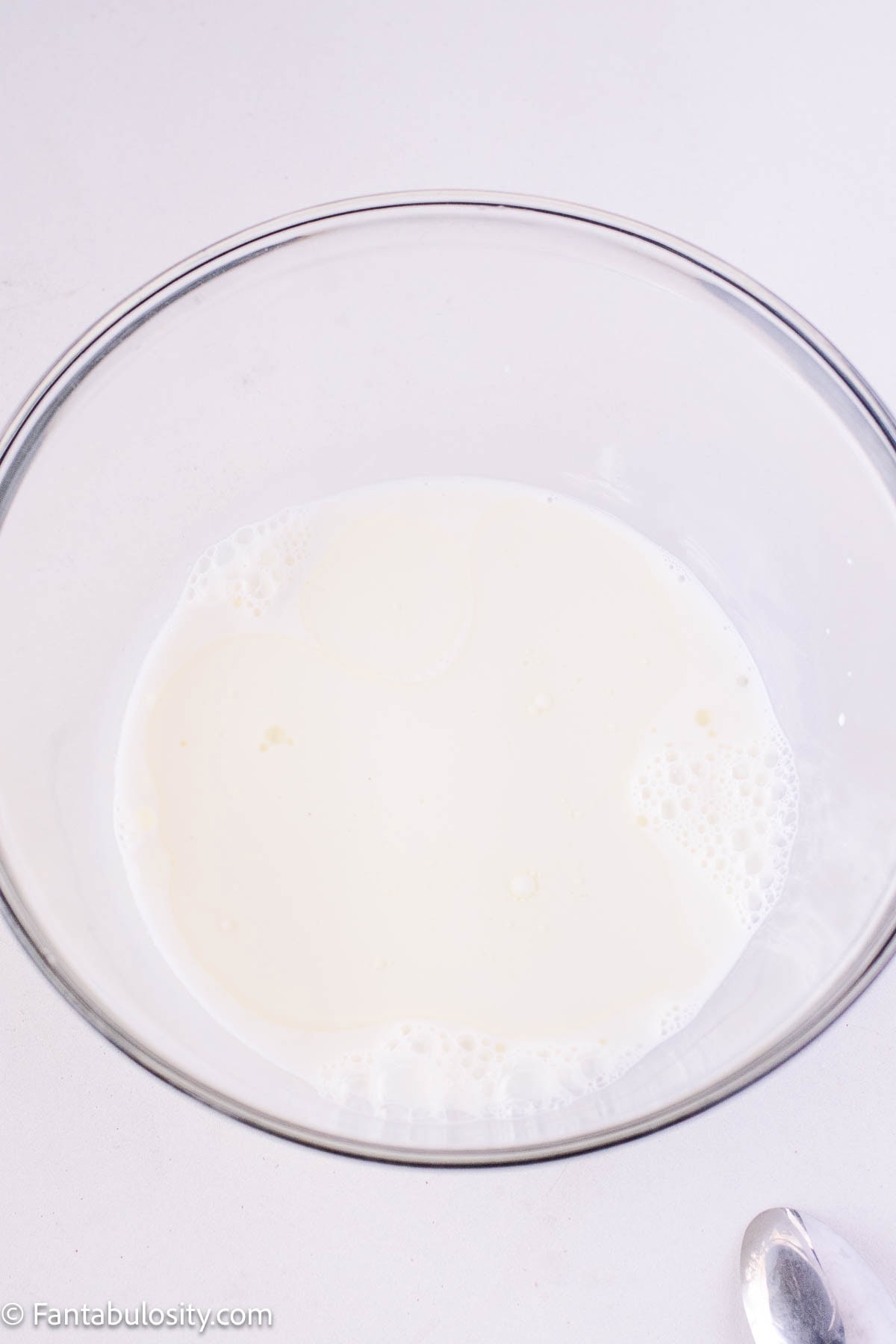 Milk and sugar in glass mixing bowl.