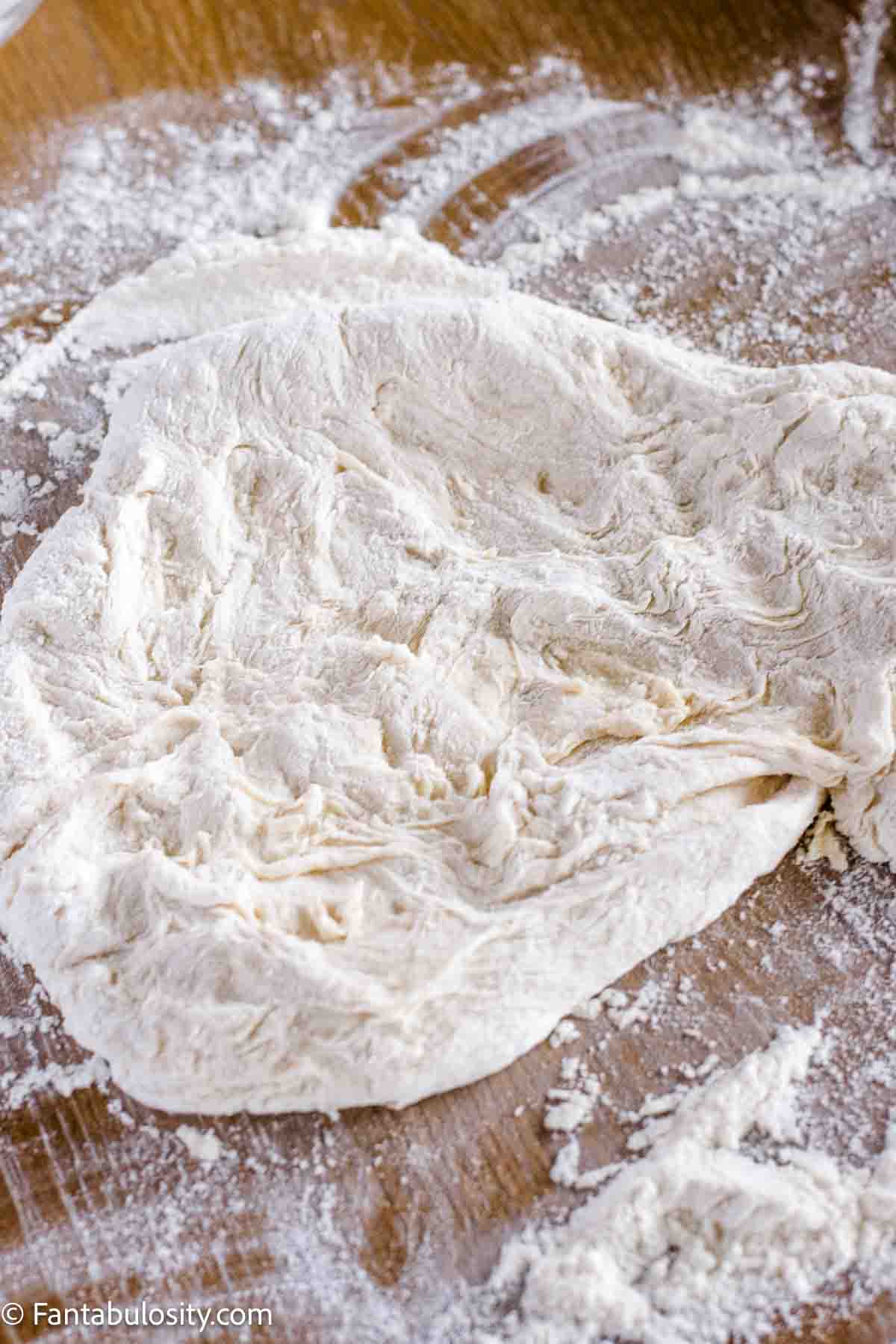 Dough on floured surface, showing it's ready for kneading.