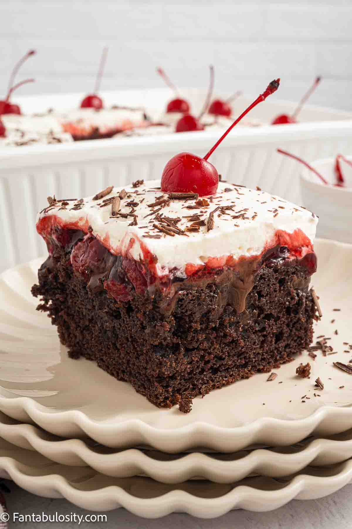 A slice of Black forest poke cake on a plate.