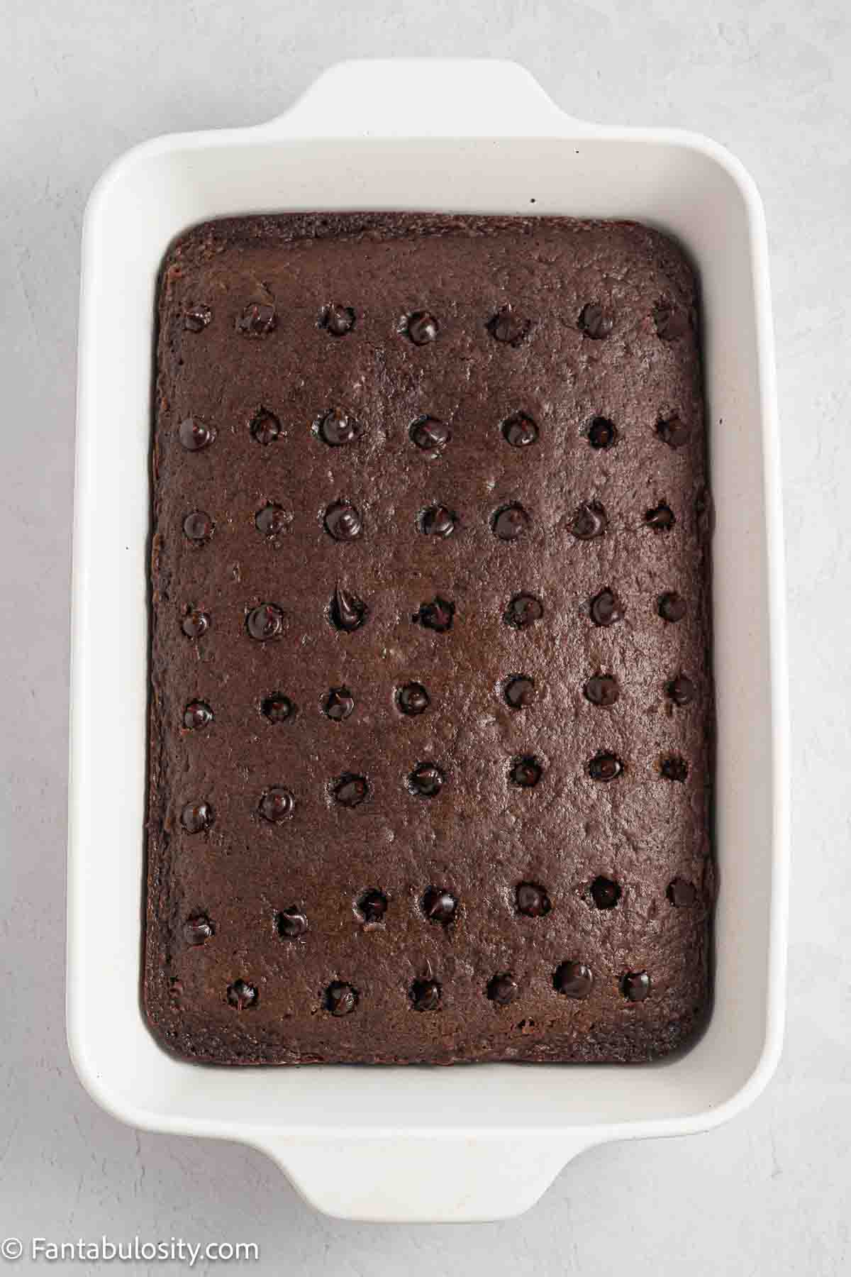 Baked chocolate cake with holes poked in the top.