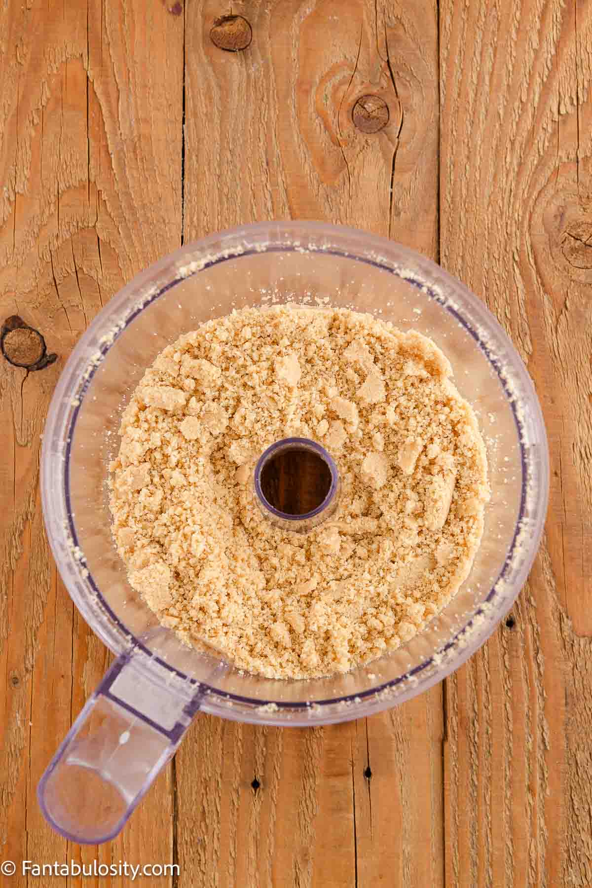 Crushed golden cookies in food processor.