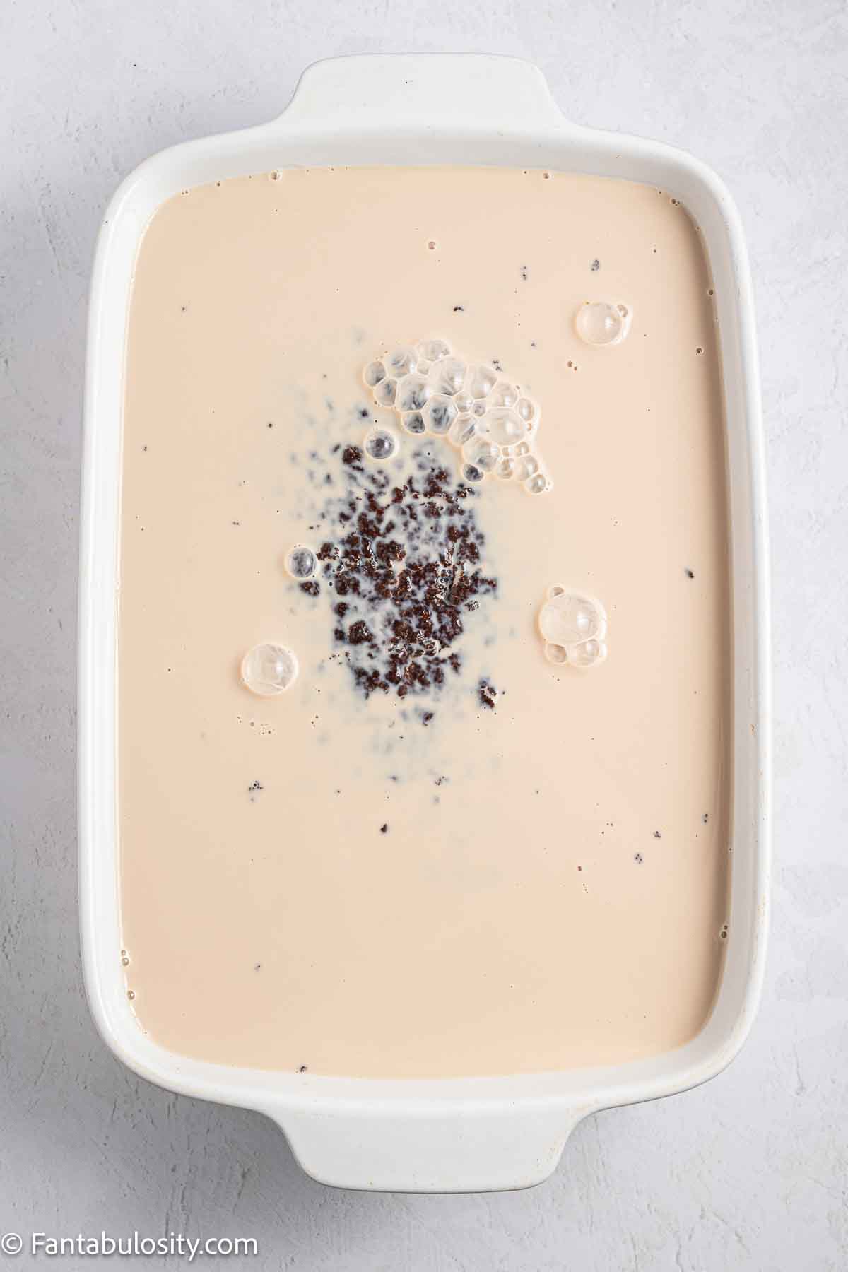 Chocolate milk, evaporated milk, sweetened condensed milk poured over the top of chocolate cake.