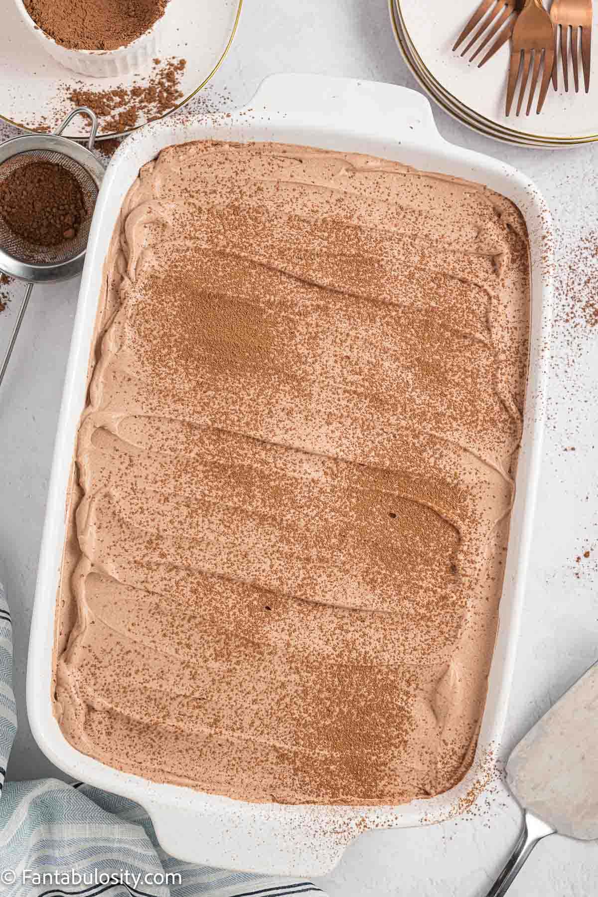Frosted chocolate tres cake in baking pan.