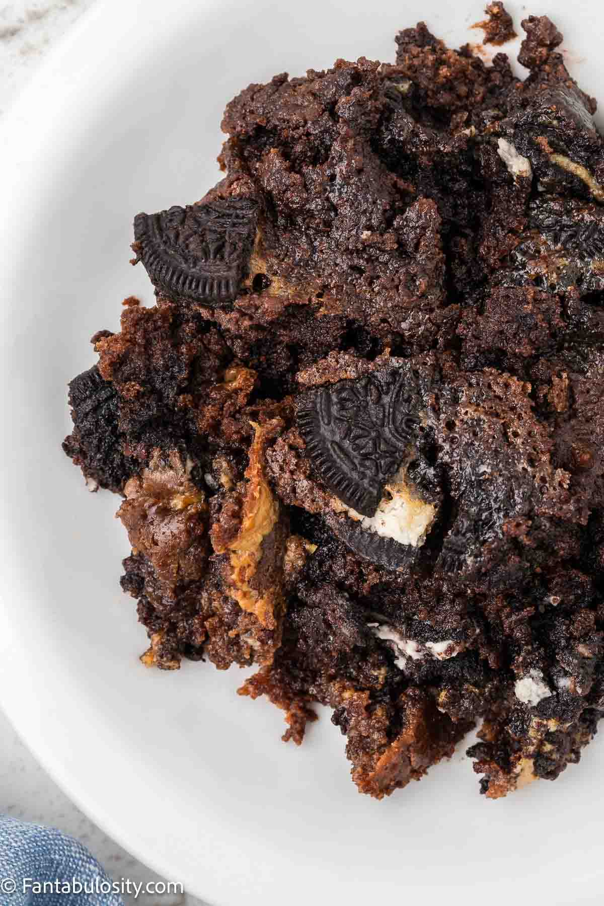 Serving of Oreo dump cake on a round plate.