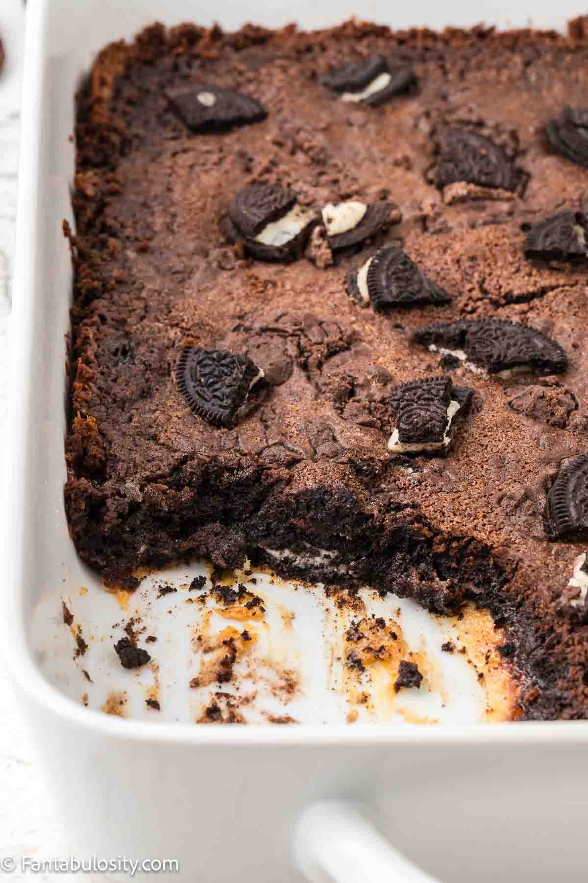 Baked Oreo dump cake with a serving scooped out of the dish, showing the inside of the cake.