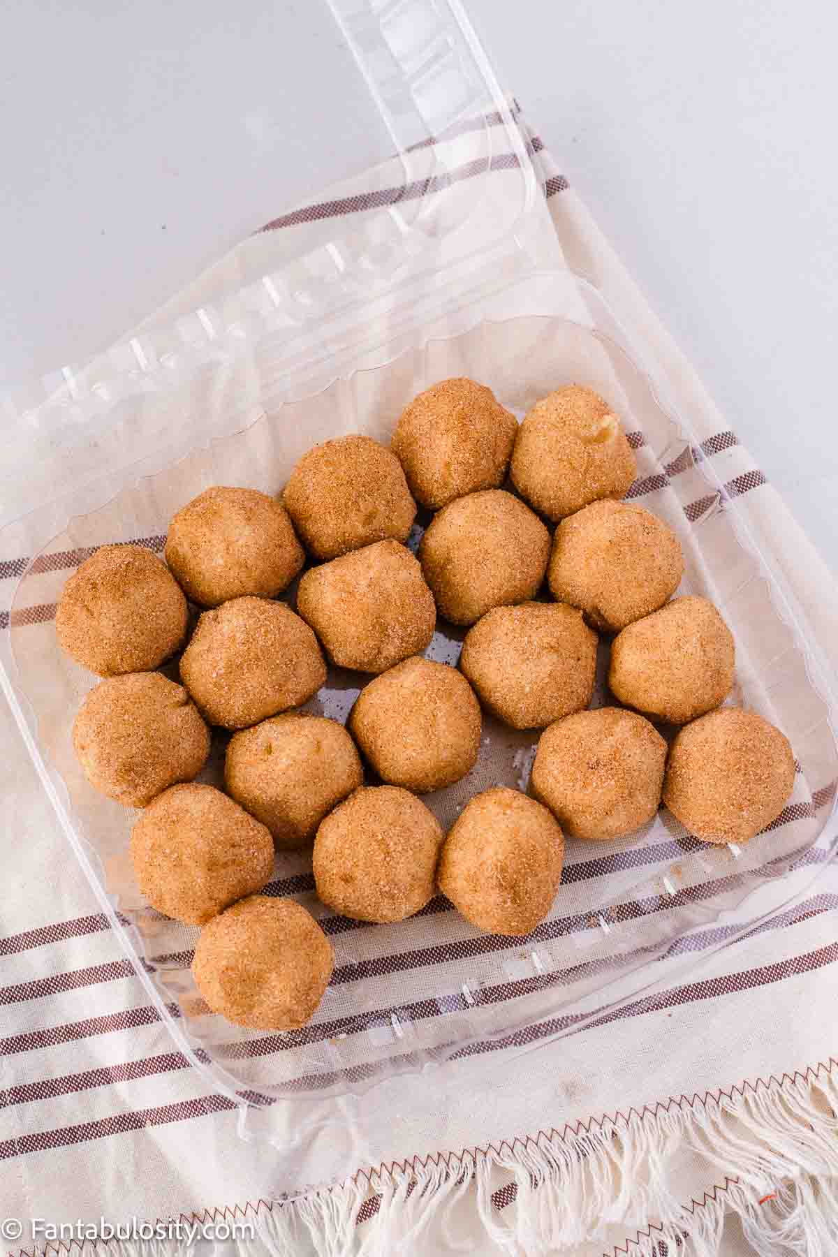 Snickerdoodle cookie dough balls in container.