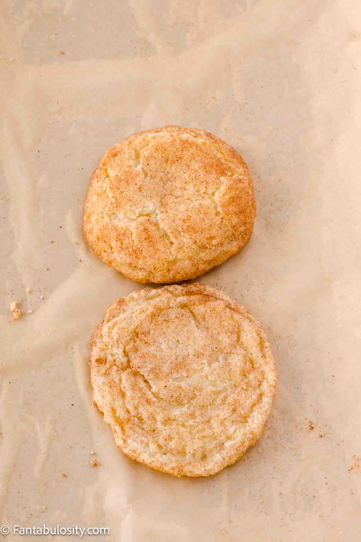 Two cookies on baking sheet, to show what chilling and not chilling results look like in snickerdoodles.