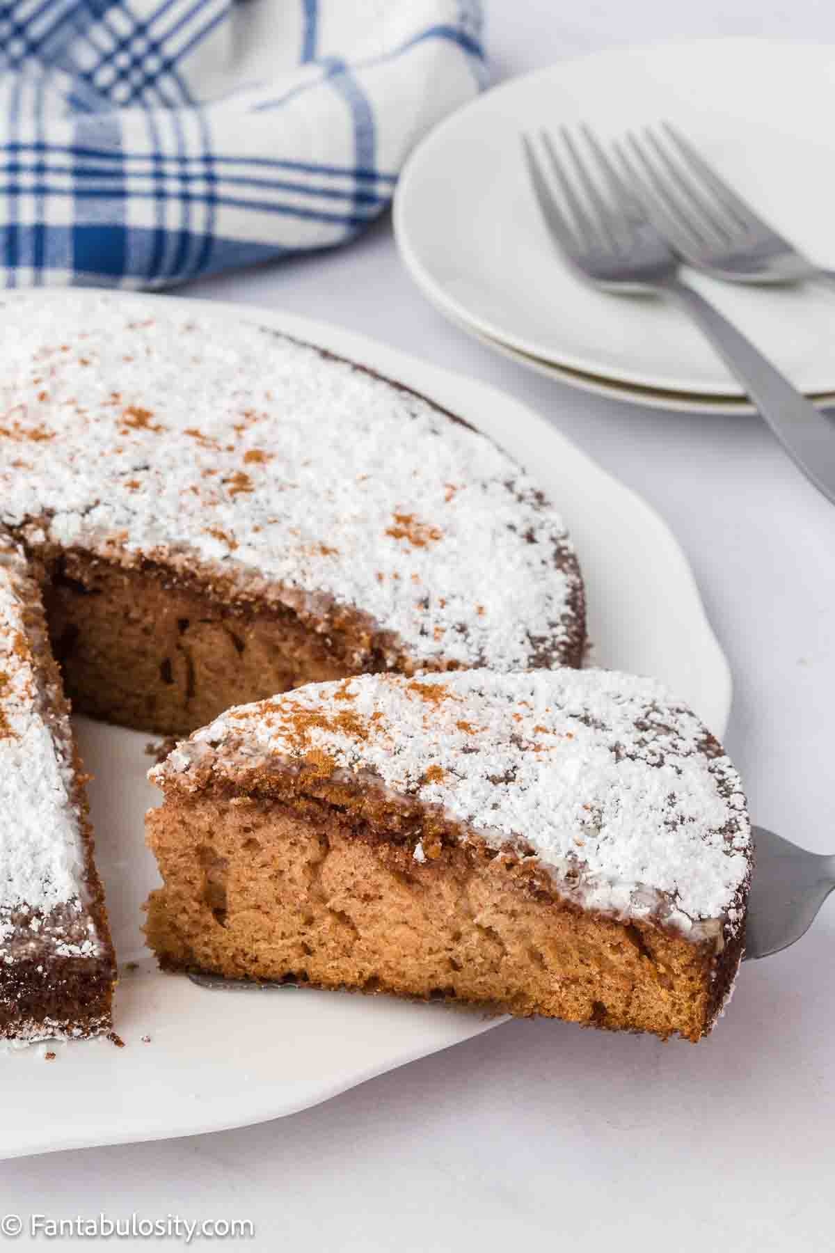 A slice of supper cake being pulled away from the rest of the cake.