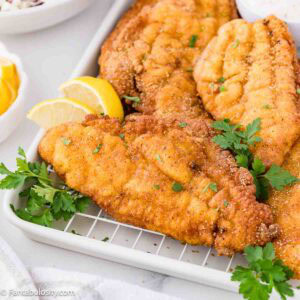 Fried Catfish on a platter with fresh parsley.