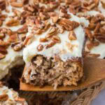 A slice of preacher cake on a wooden spatula, resting above the rest of the cake.
