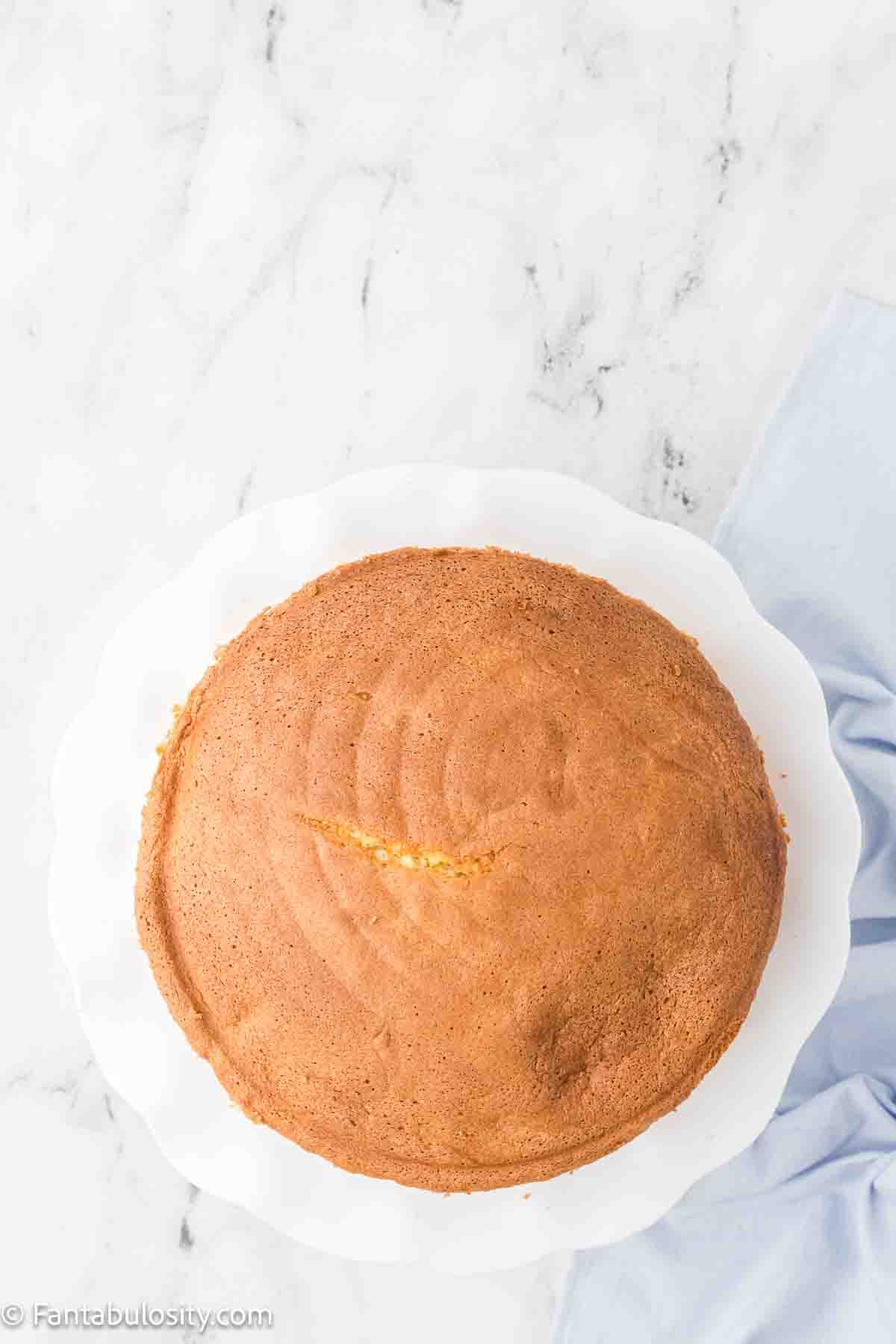 Baked cloud cake, upside down on cake platter.