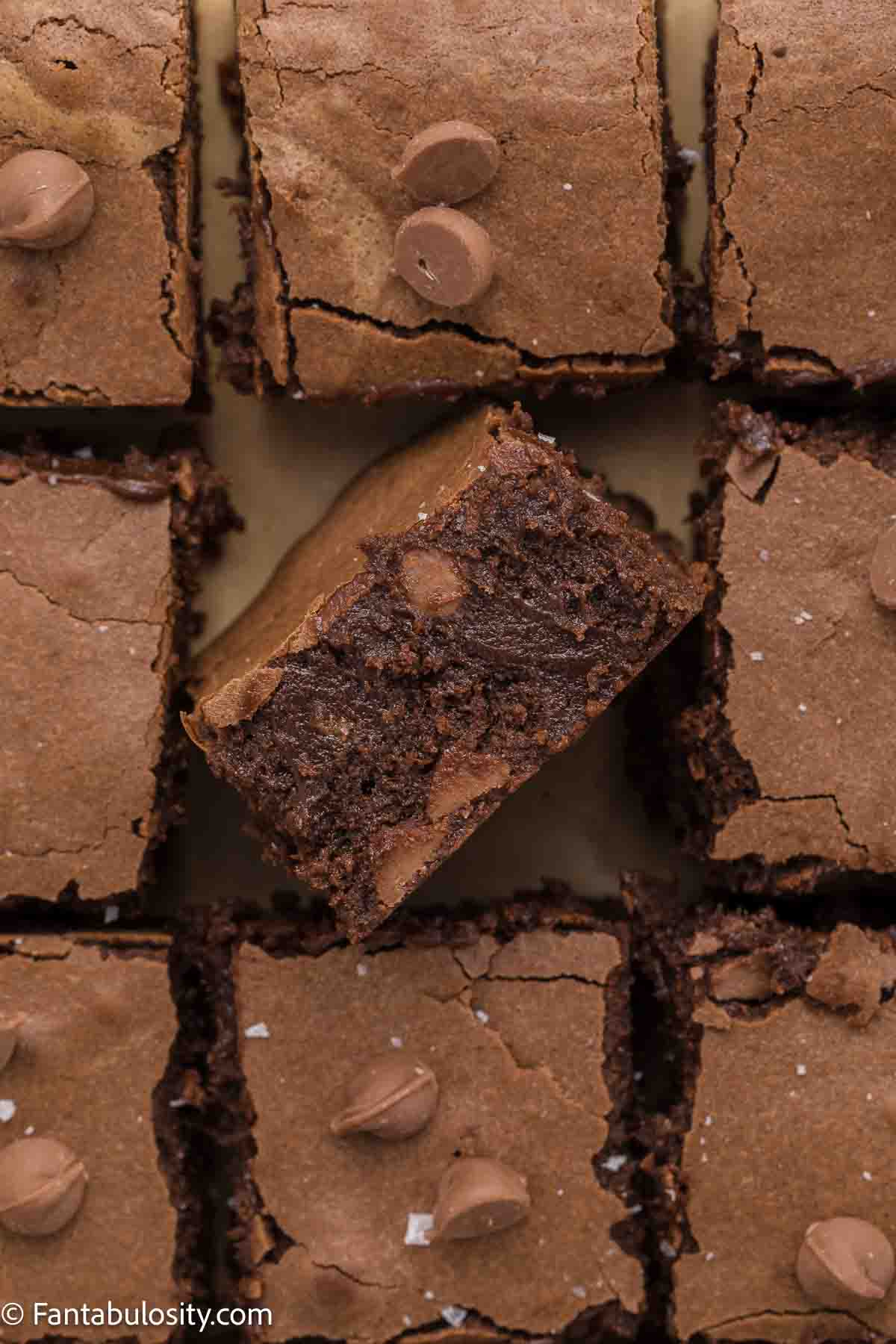 Condensed milk brownies cut and the one in the middle flipped up on the side.