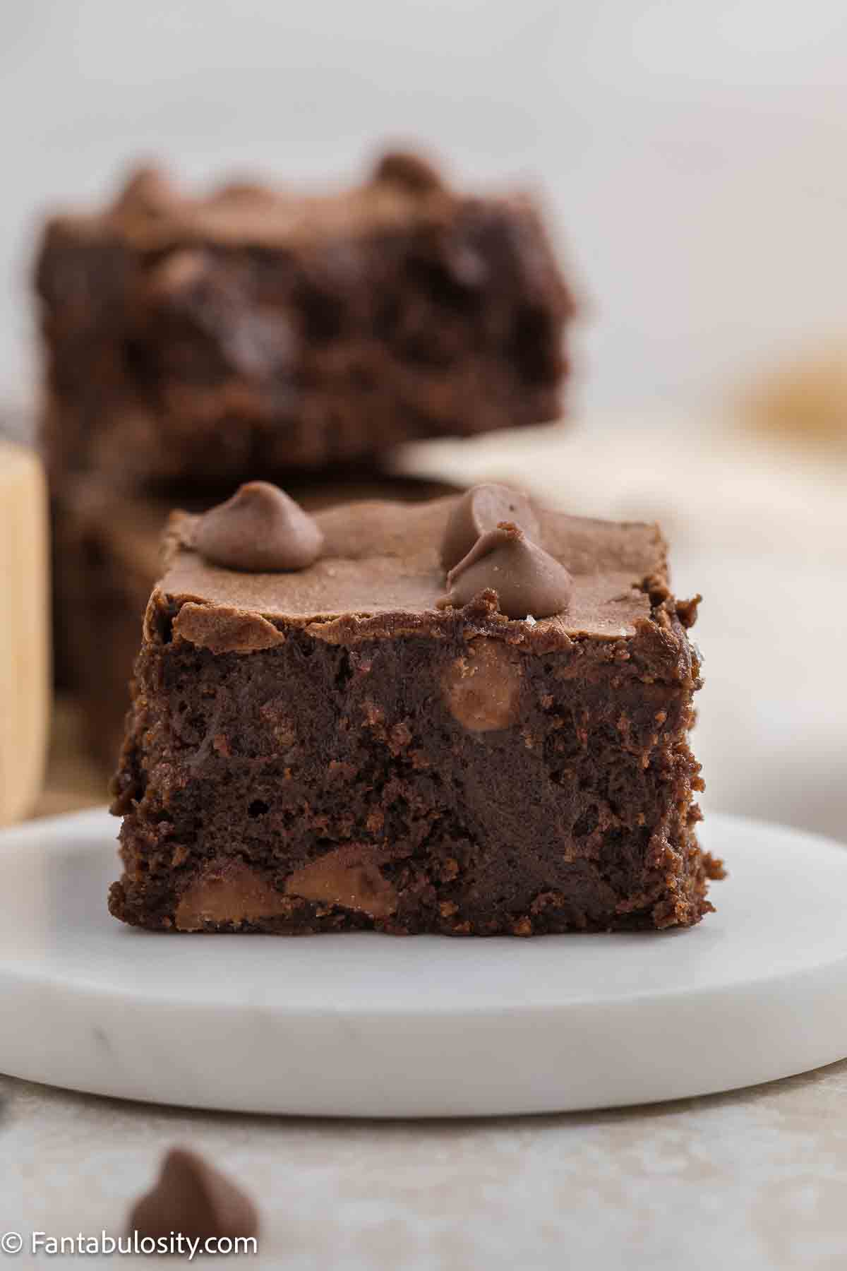 Condensed milk brownie on plate, topped with chocolate chips.