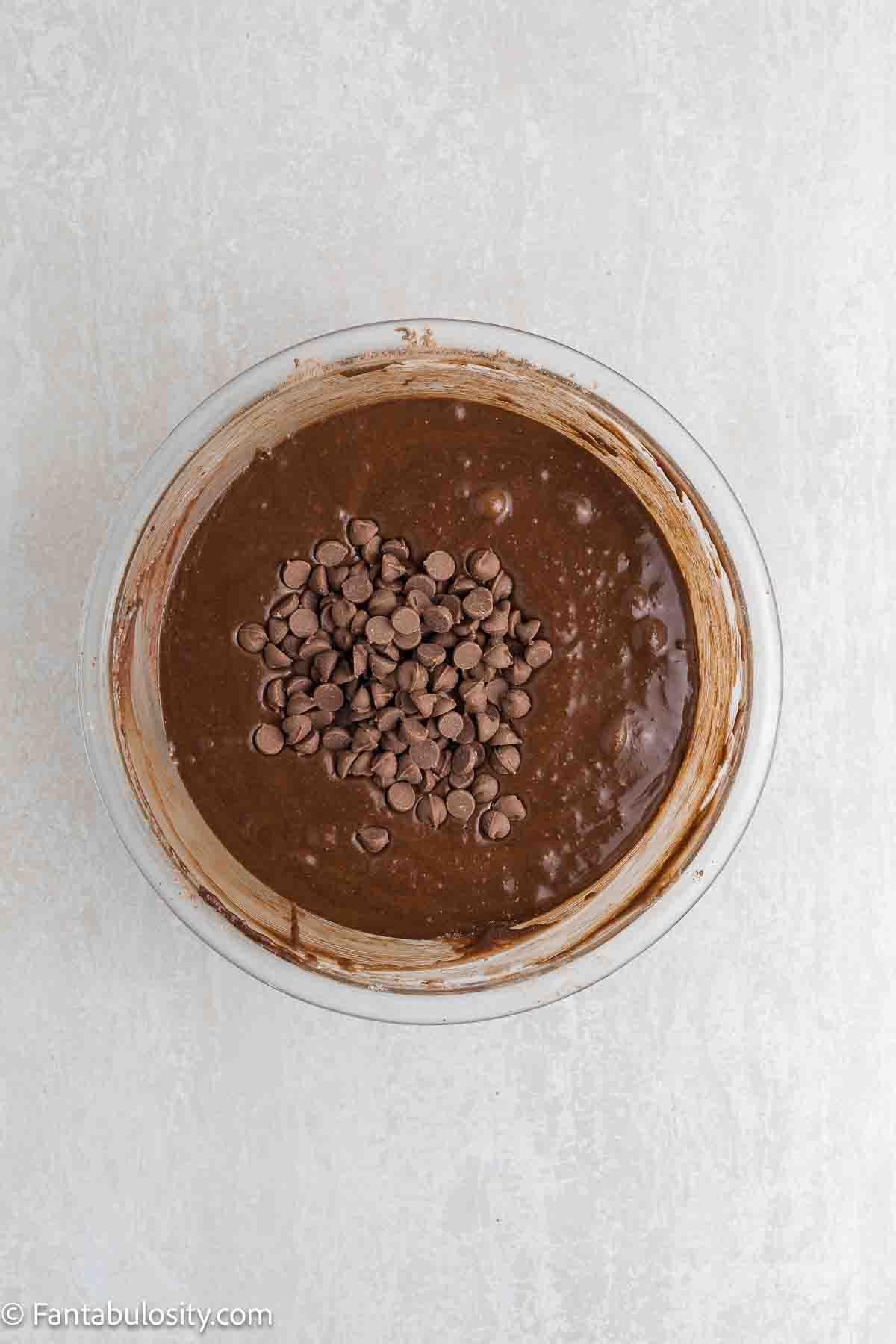 Chocolate chips added to chocolate mixture in mixing bowl.